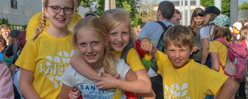 Kinder und Jugendliche lachen und umarmen sich. Sie strahlen Gemeinschaft aus.