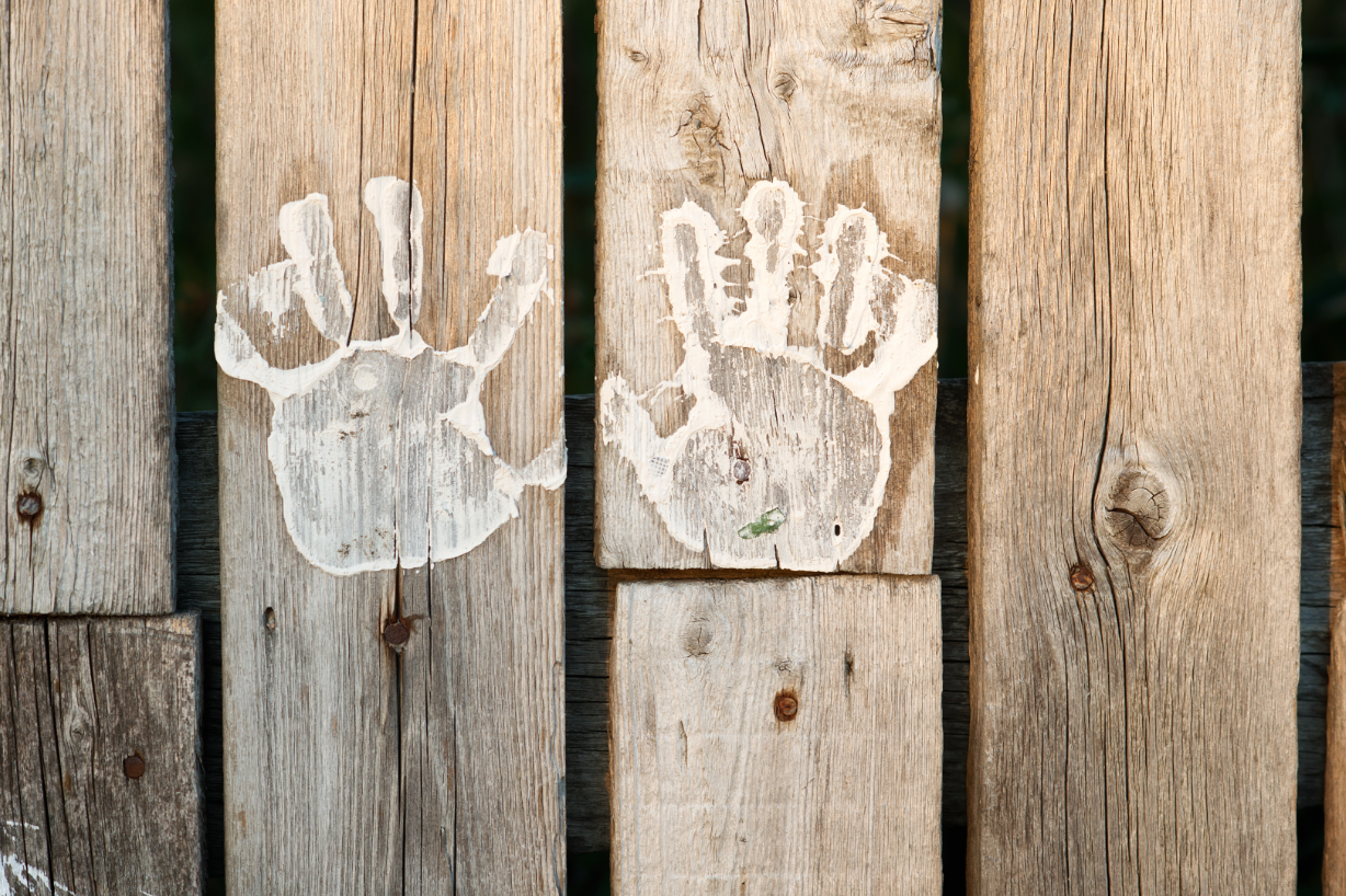 Handabdrücke auf einer Holzwand.