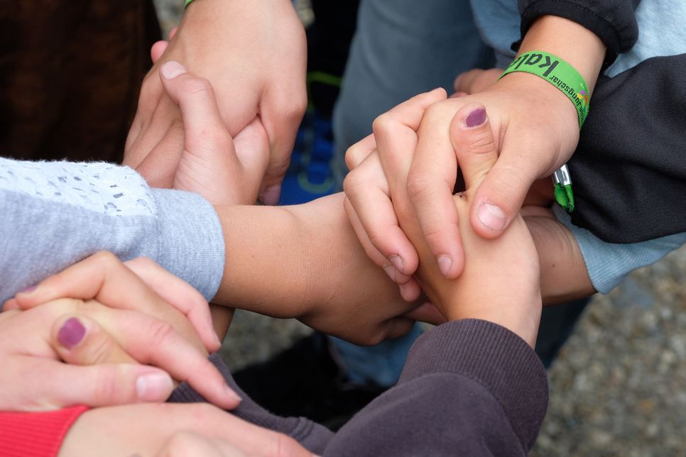 Viele Menschen reichen sich die Hände. Foto: Hanner