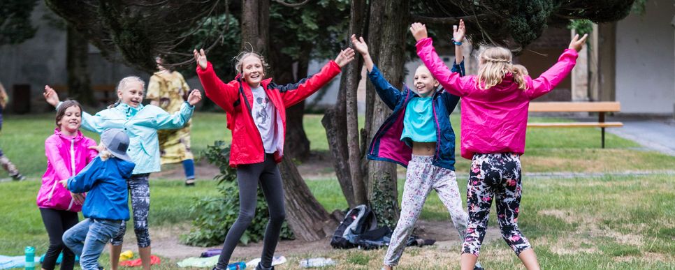 Kinder spielen miteinander auf einer Wiese.